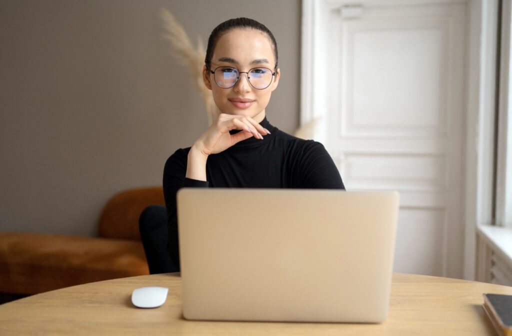 A person wearing corrective glasses with anti-reflective coating while working at a computer.