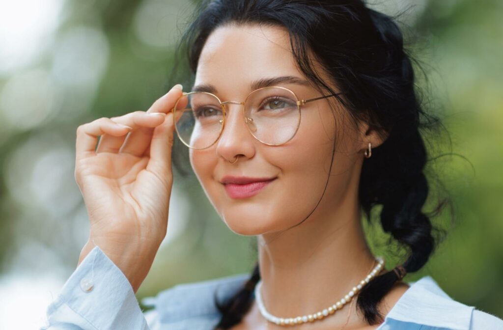 A model wearing thin gold framed glasses as they look in the distance